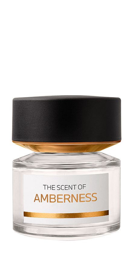 bmw-nobilis-group-packshots-880x440-AMBERNESS - BERGERAT | WE MAKE BEAUTY PERFORM Perfume bottle with a black cap, clear glass body, amber-tinted liquid, and a white label reading 'The Scent of Amberness' with a gold stripe beneath it.
